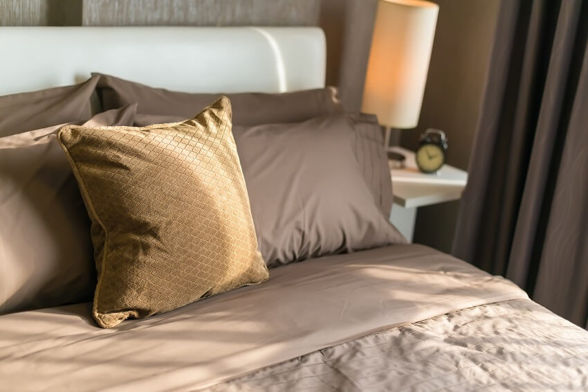 Brown theme bedroom with decorative and brown pillows and bedding