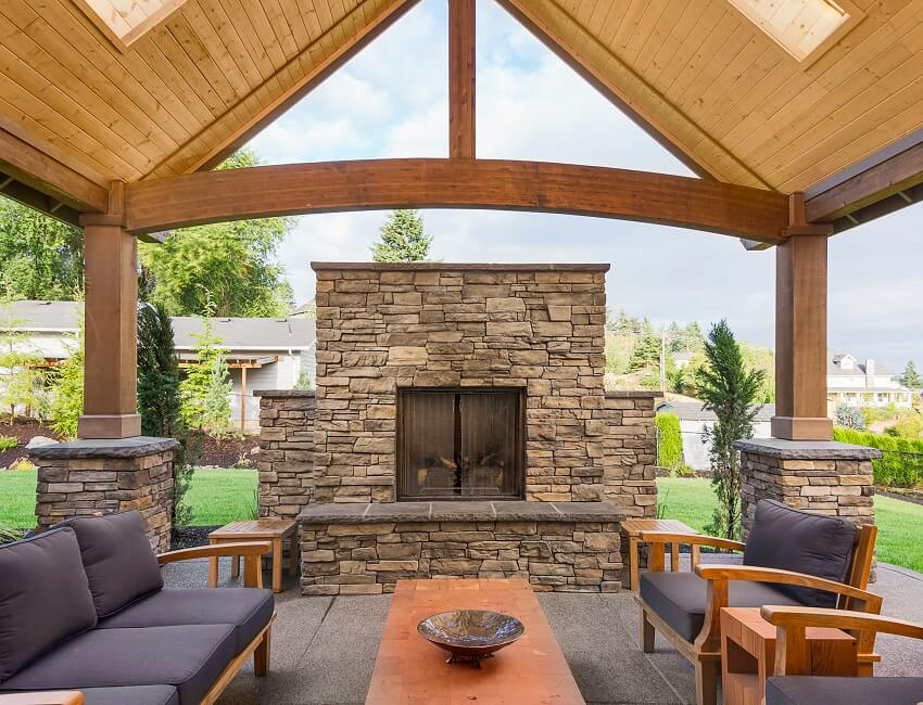 Covered patio with chairs and fireplace