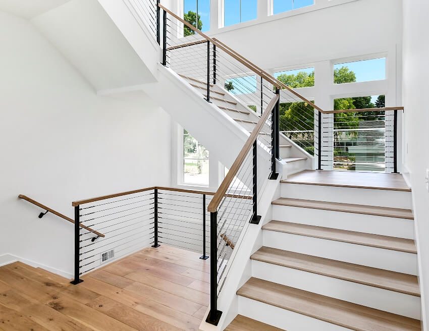 Elegant wood stairs leading up and down with many windows