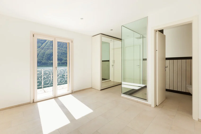 Empty bathroom sandstone floor glass door shower area