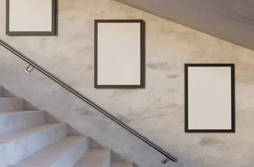 Empty frames hanging from staircase wall metail handrail stairs