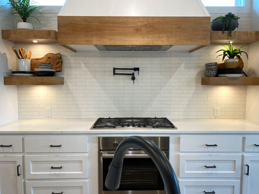 Farmhouse kitchen tile backsplash countertop white drawers floating shelves hood stove