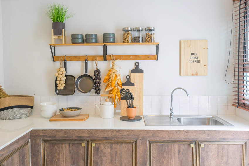 Farmhouse kitchen wood cabinets stainless steel sink white walls countertop shelf window blinds