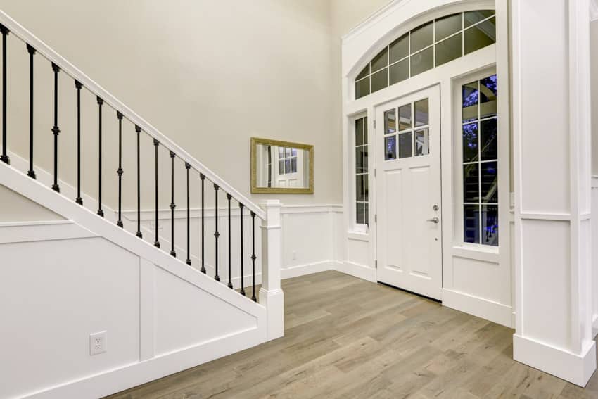 Front door interior stairs railing wood flooring white wall