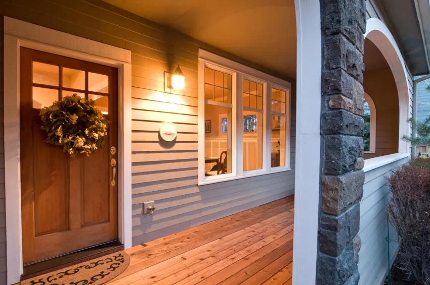 Front porch siding, wood flooring, front door and wall sconce