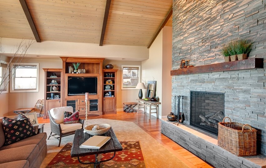 Furnished room in luxury home with stacked stone fireplace