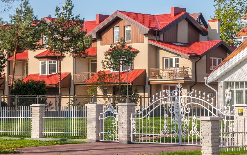 Gated luxury home with red roof in suburb