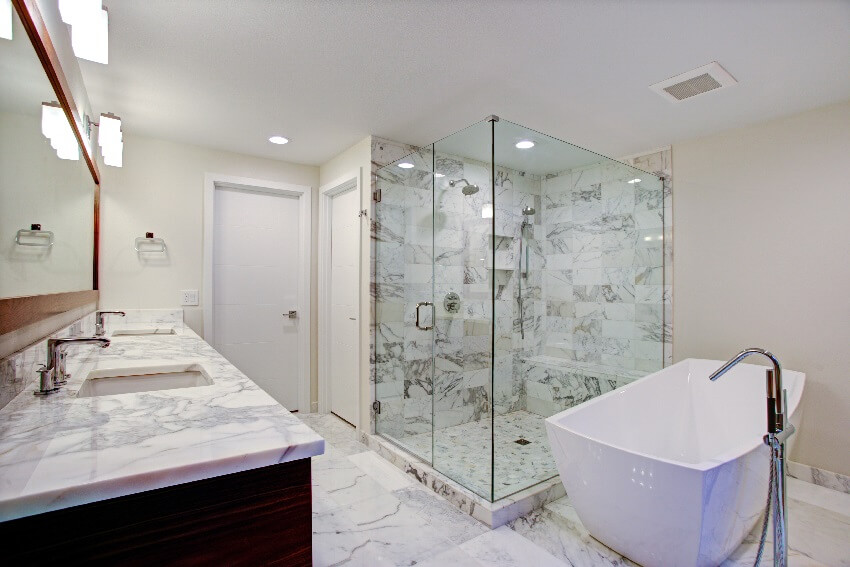 Gorgeous bathroom with composite marble countertop and shower walls white bathtub shower with glass partition and a mirror