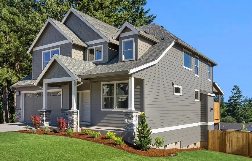 Grey home with lawn wood fence garage and basement