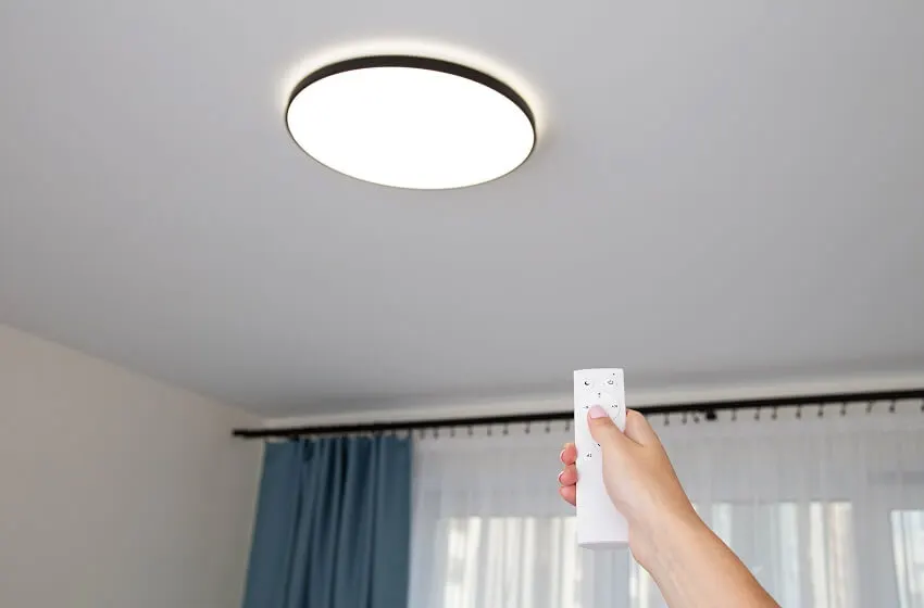 Hand switching on or off the led ceiling chandelier with a remote control