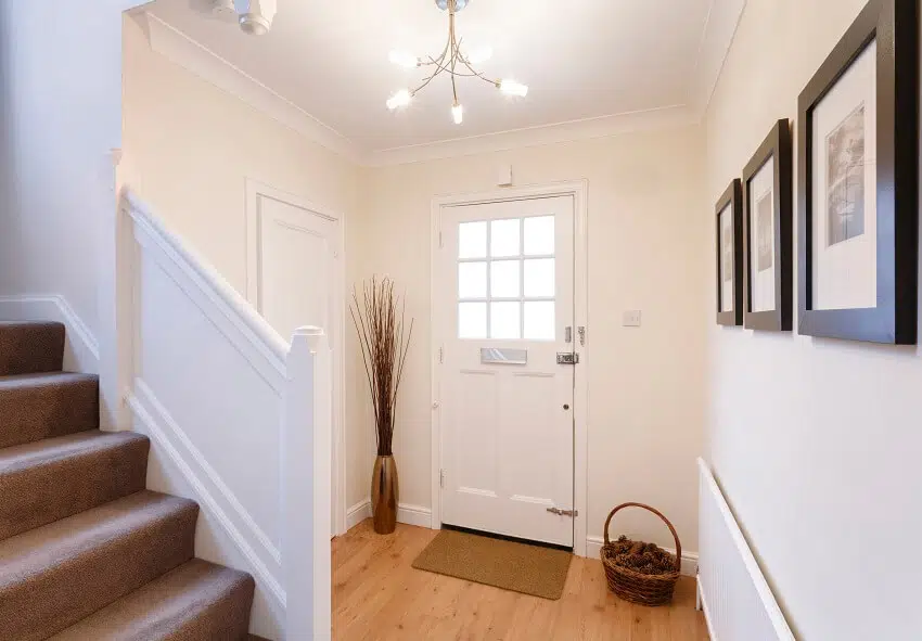 Home interior showing hallway with basket and frame decors and carpeted stairs