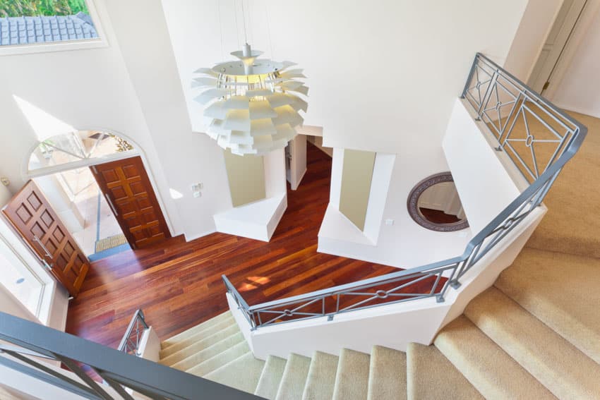 House interior with painted stair railings wood floor chandelier white wall