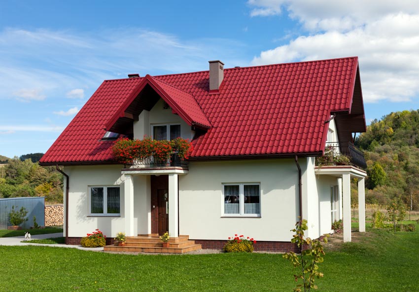 House with red metal roof front door white wall chimney