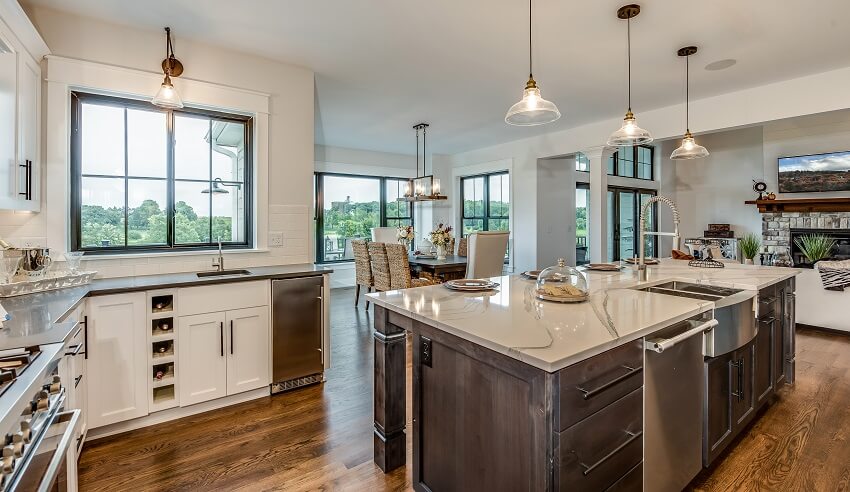 Kitchen island pendant lights and hardwood flooring in an open kitchen with view of dining area and living room