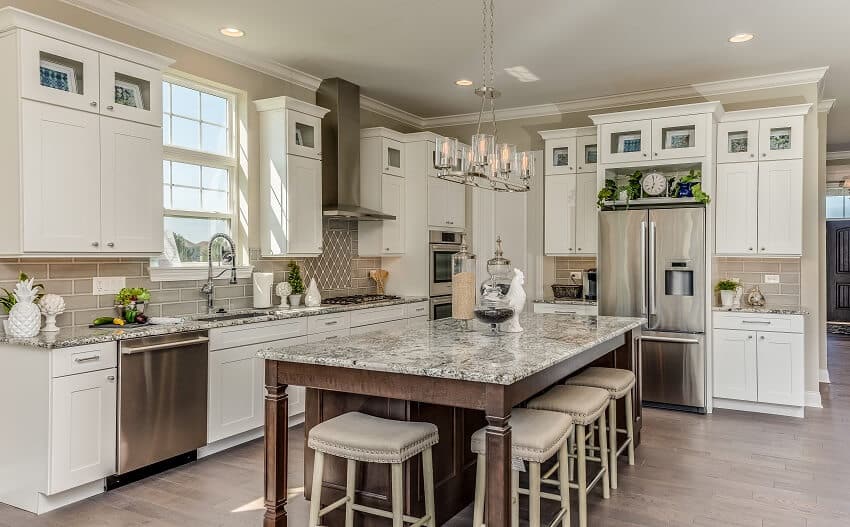Kitchen with ample seating for dining around the island quartz countertops and white staggered cabinets