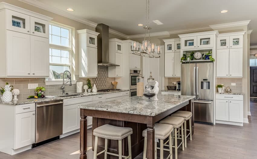 Kitchen with higher and lower cabinets with seating for dining around the island quartz countertops