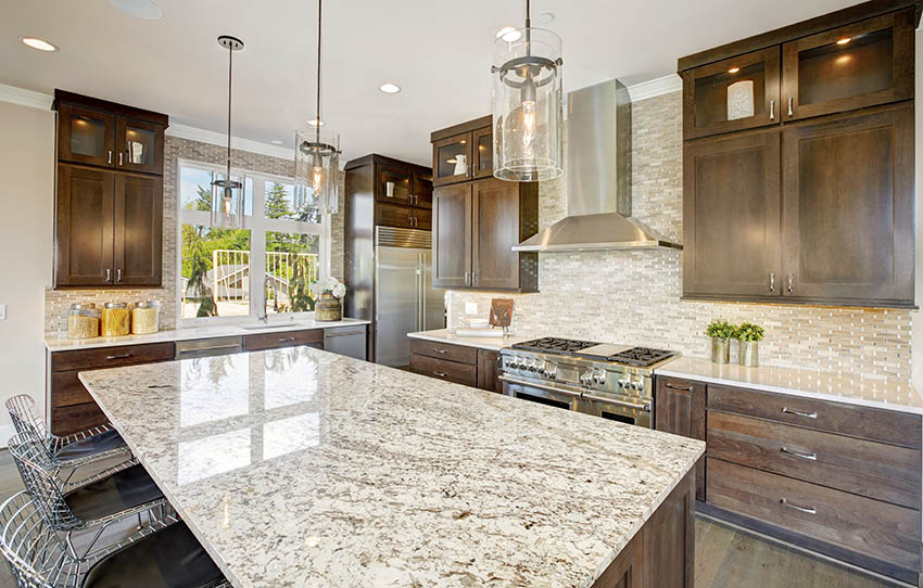 Kitchen with light granite countertops solid wood cabinets pendant lighting full wall backsplash
