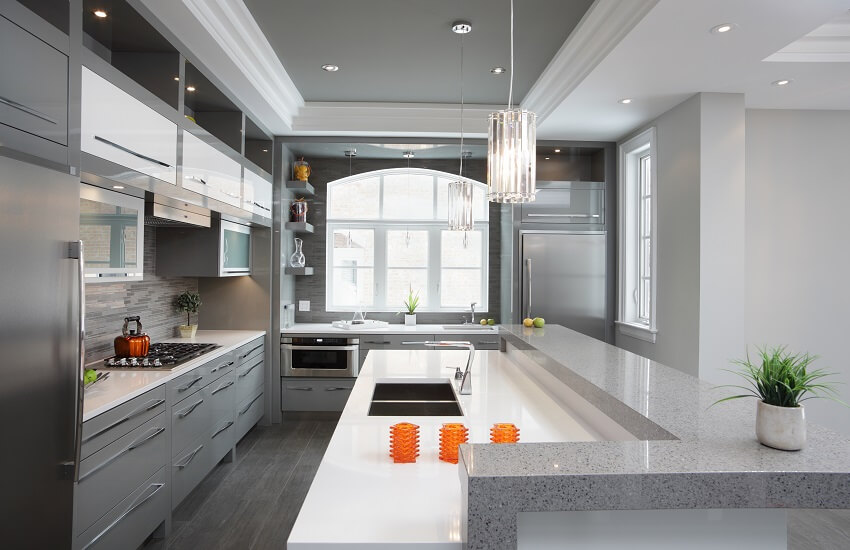 Kitchen with grey cabinets and stainless steel appliances with double basin peninsula