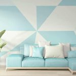 Light blue and white geometric wall clock couch indoor plants