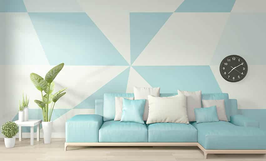 Light blue and white geometric wall clock couch indoor plants