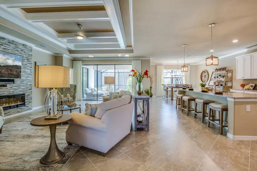 Open space layout with travertine floors, chairs, lamp, windows, hanging lights, and stools