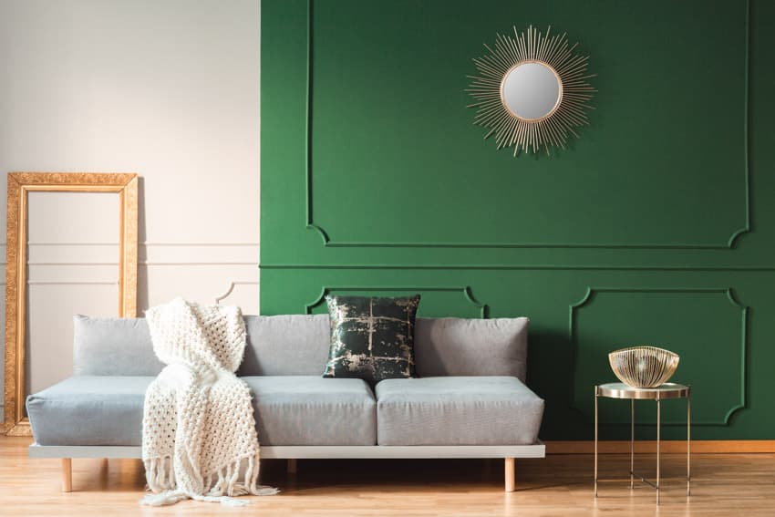 Living room gray couch green accent wall mirror wood floor cushion frame