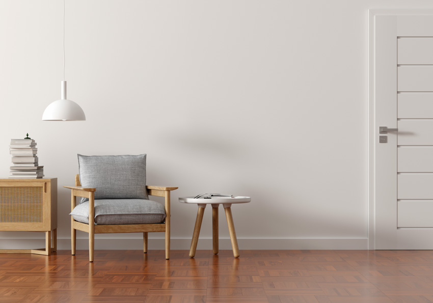 Living room with linoleum floors chair coffetable hanging light white wall door