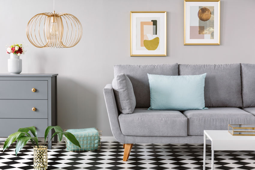 Living room with linoleum floors gray couch drawer artwork on wall coffetable