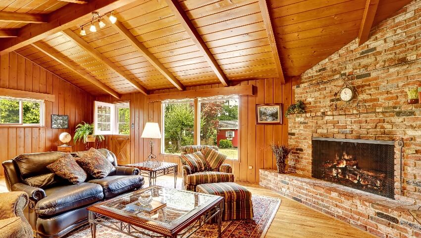Log cabin house interior with vaulted ceiling fireplace leather couch and glass top table