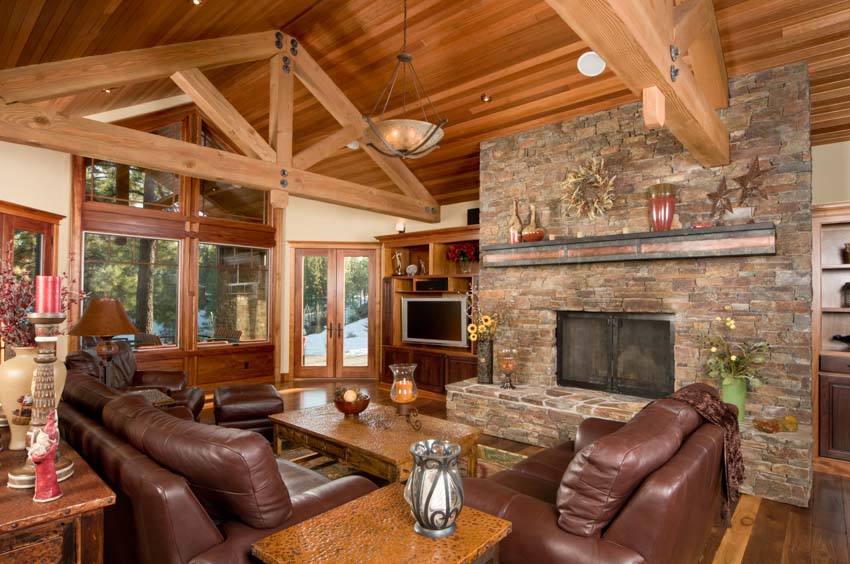 Log cabin wood ceiling flooring leather couch brick fireplace