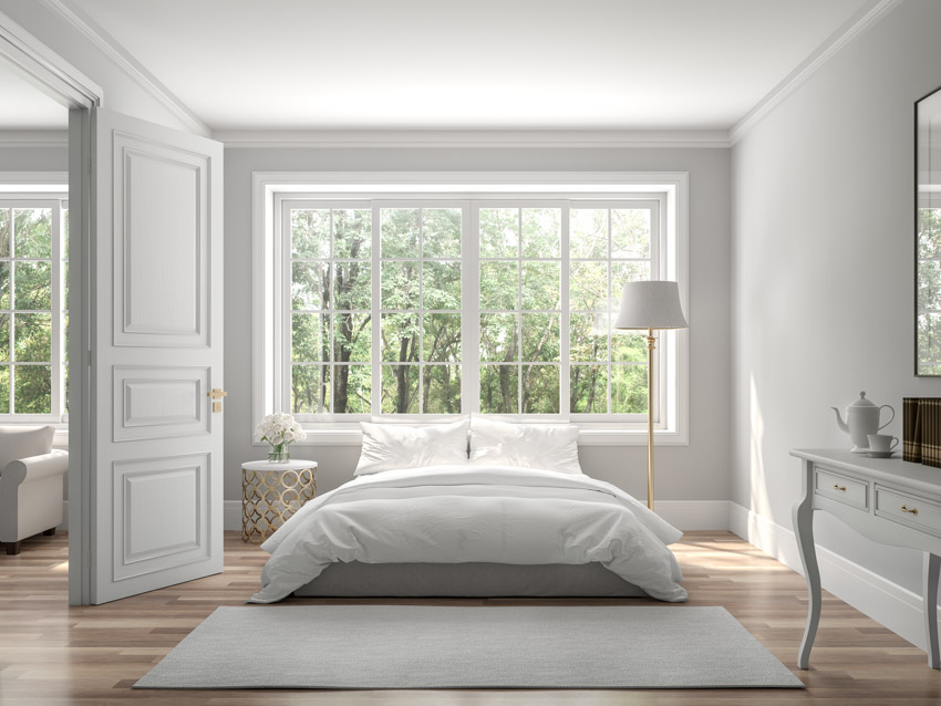 Masters bedroom with wood floor vinyl windows lamp white wall door rug