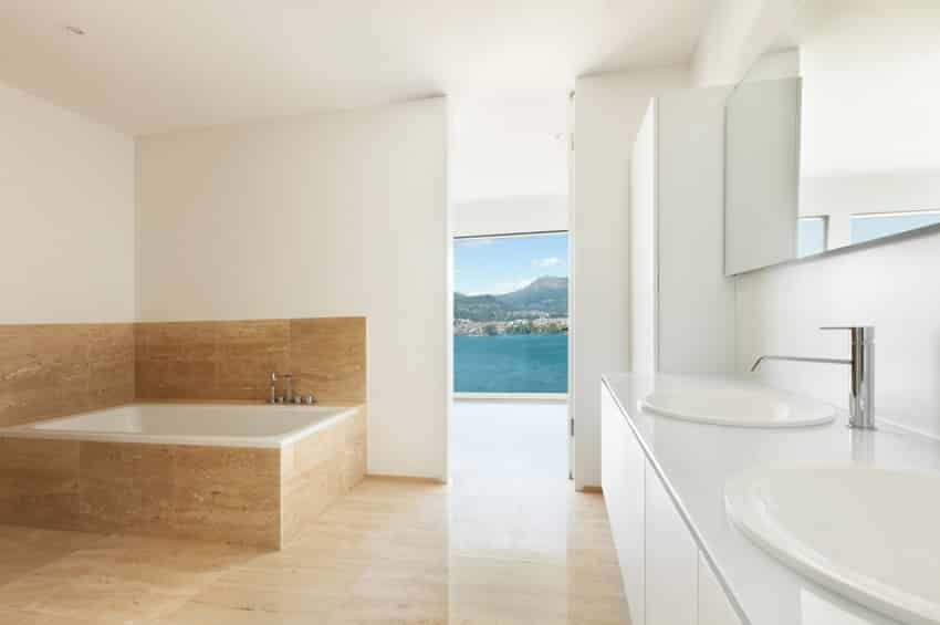 Modern bathroom tile flooring white wall countertop sink mirror drop in tub