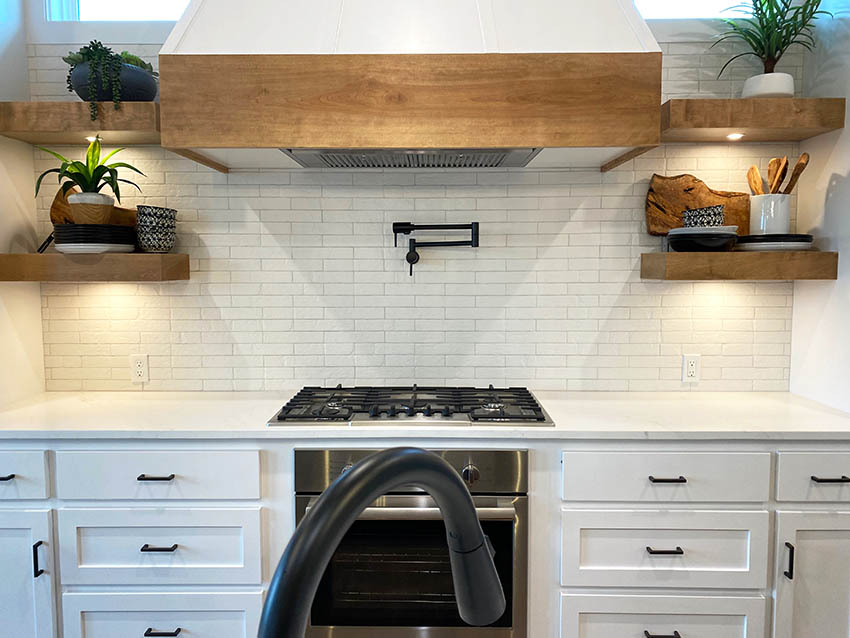Modern farmhouse galley kitchen with wood range hood white cabinets white horizontal tile