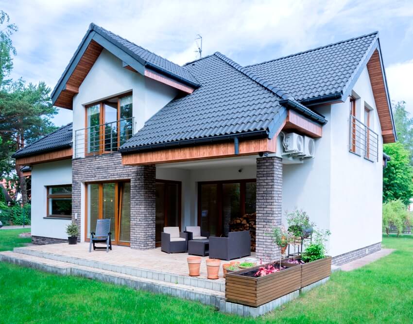 Exterior with roof overhang and terrace surrounded trimmed green lawn