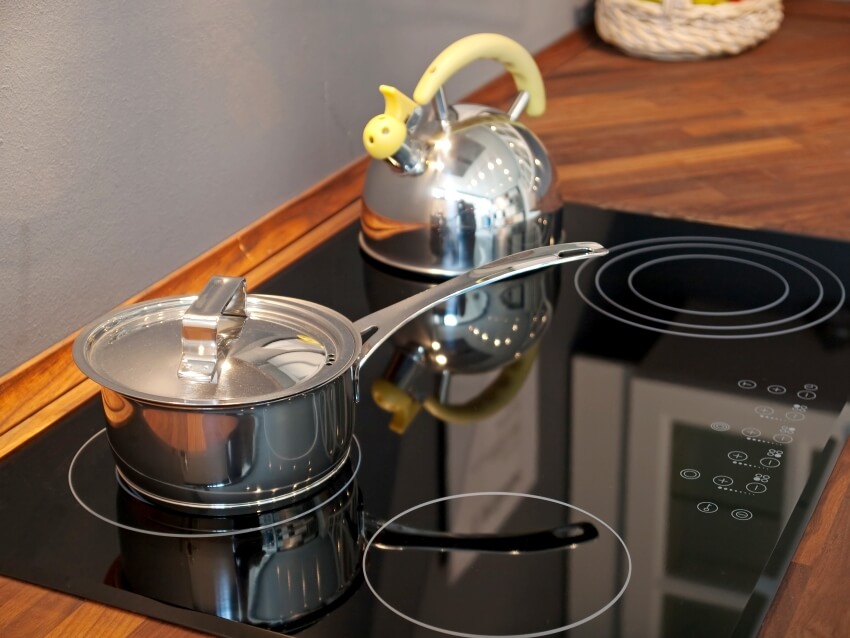 Modern kitchen ceramic stove with kettle and pan on it