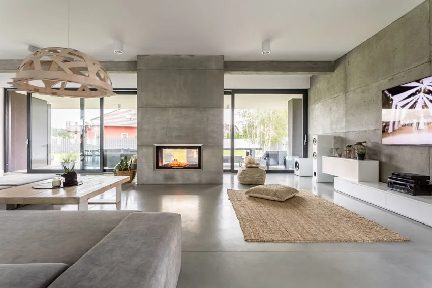 Modern living room concrete wall column floors rug windows hanging light