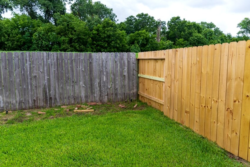 New and old privacy wooden shiplap fences in back yard