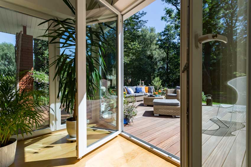 Glass pivot door leading to a small country style deck