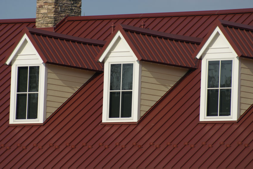 Red metal roof with dormers windows chimney