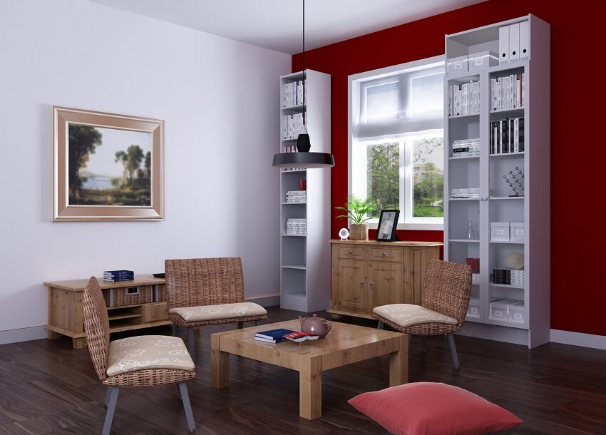 Room with books white open shelves and maroon walls and wooden floors