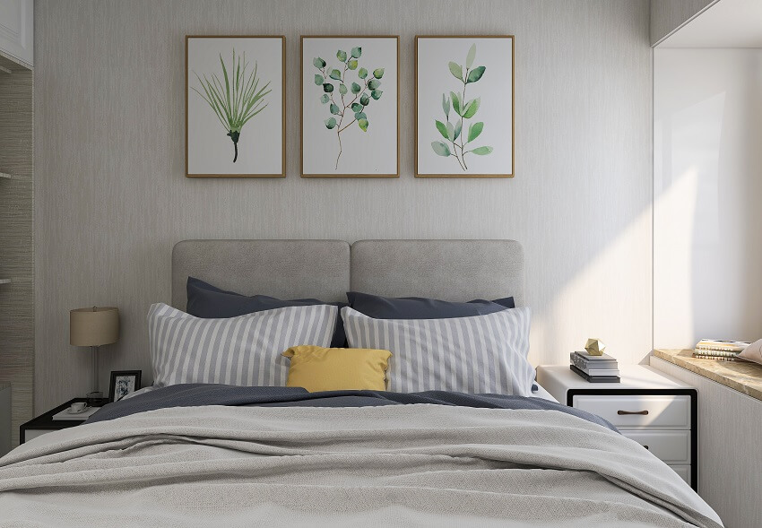 Small bedroom with natural light table cabinet lampshade decors on wall and bed with pillows grey linen sheets