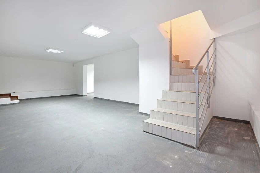 Stairs to empty basement white storage room