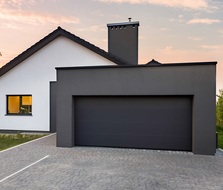 Stylish house with garage cobblestone driveway and black chimney