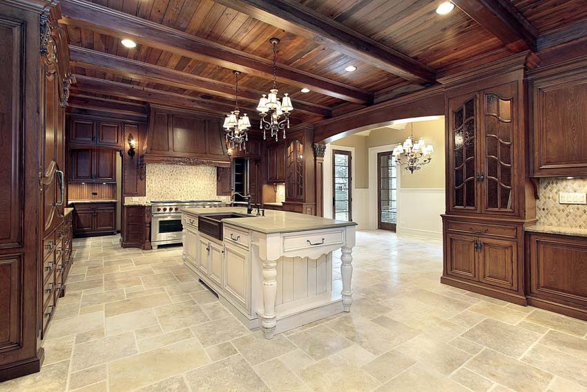 Kitchen with white island, marble floors and recessed lighting