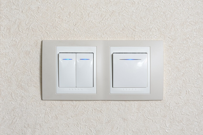 Two switches with blue illumination on wall