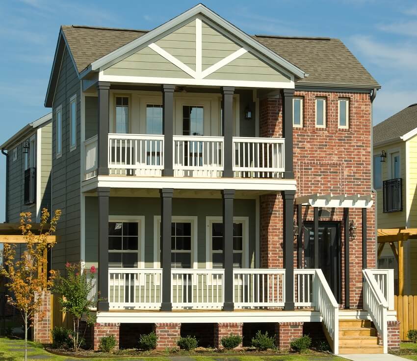Two story red brick house with front porch and balcony