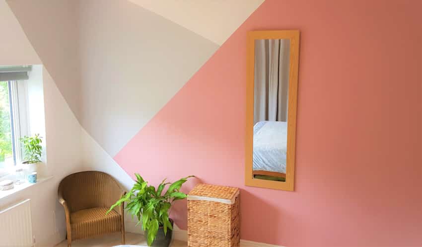 White and pink geometric wall mirror window chair indoor plant