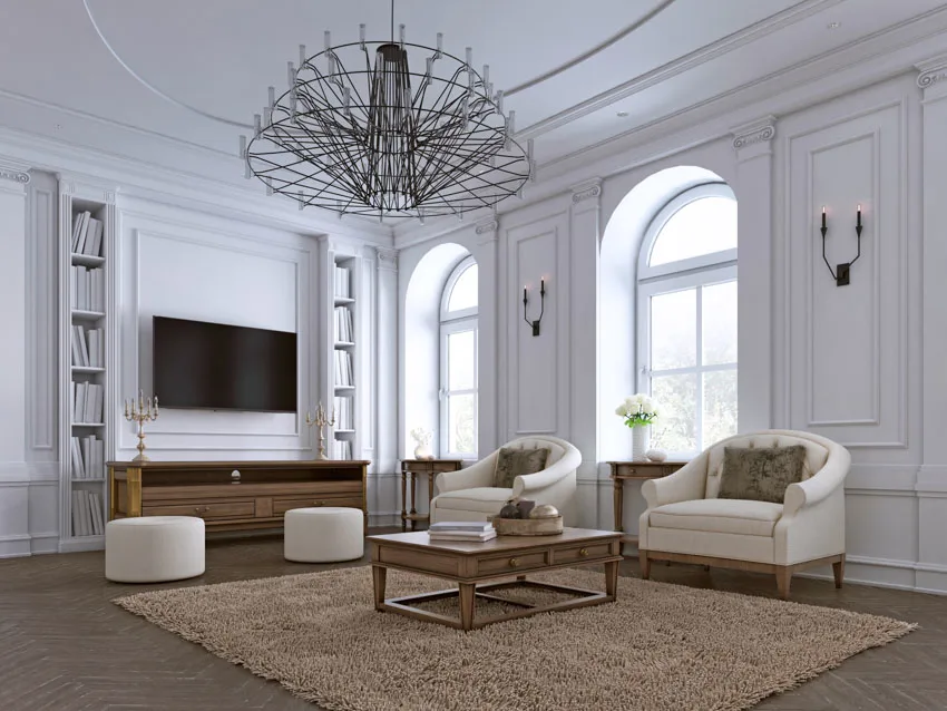 White room with arched windows, brown rug and narrow bookshelf