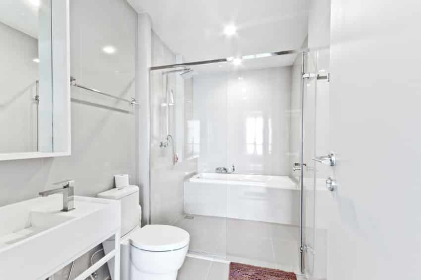 White bathroom toilet alcove bathtub sink glass door shower