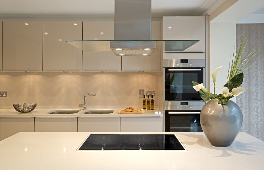 White kitchen with extractor fan & lights suspended from above 